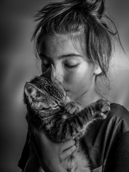 Femme embrassant tendrement un chat, symbole de l’univers de la marque de t-shirts ésotériques Lune & Moustache.